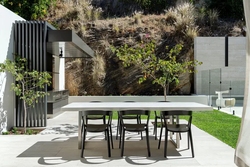Outdoor dining terrace beside a landscaped wall
